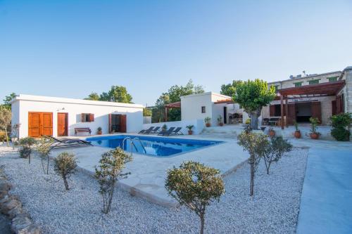 a villa with a swimming pool and a house at Chloe's House in Pano Akourdalia