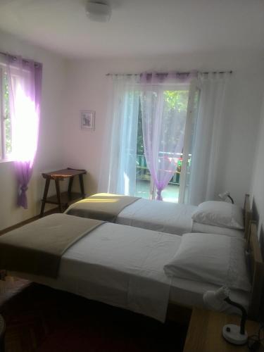 a bedroom with two beds and a window at Apartments Prisnac in Pakoštane