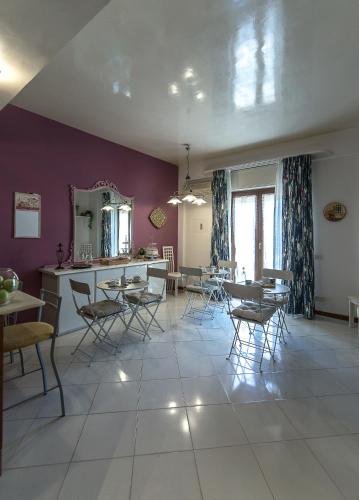 a dining room with purple walls and tables and chairs at Il Sorriso di Liu' in Agrigento