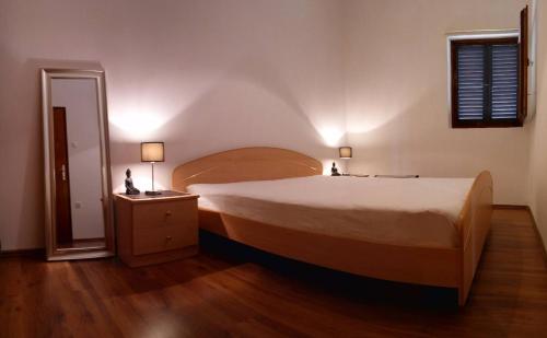 a bedroom with a large bed and a wooden floor at The Garden of Elaïs in Šibenik