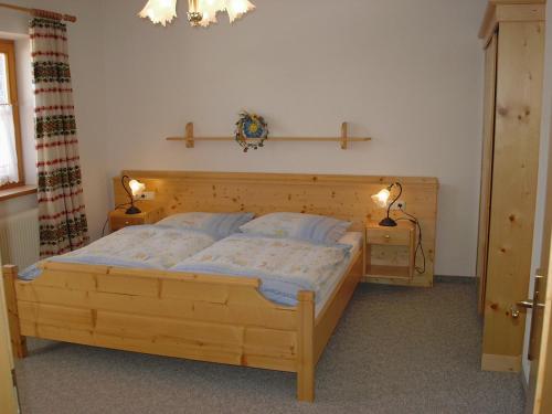 1 dormitorio con 1 cama de madera y 2 lámparas en Appartement La Piazza, en Krimml
