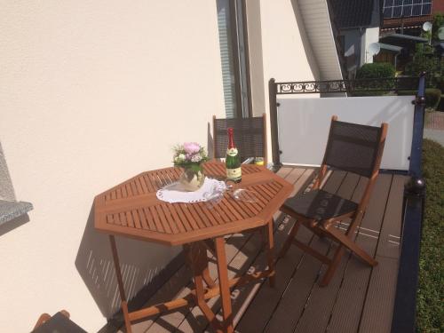 uma mesa de madeira e 2 cadeiras numa varanda em Gästehaus am Fischerweg em Lauterbach