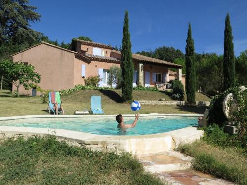 - un homme jouant avec un ballon de plage dans une piscine dans l'établissement Paradise House, à Crillon-le-Brave