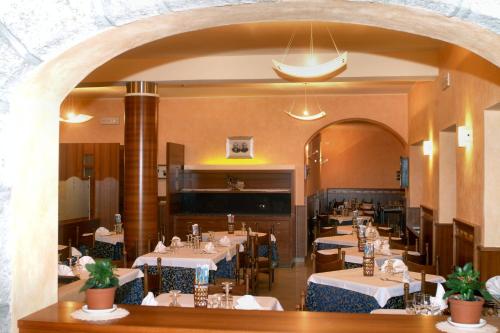 a dining room with tables and chairs and an archway at Hotel Sole in Castione della Presolana