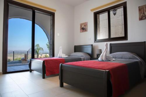 a bedroom with two beds and a large window at Valentine's House in Theletra