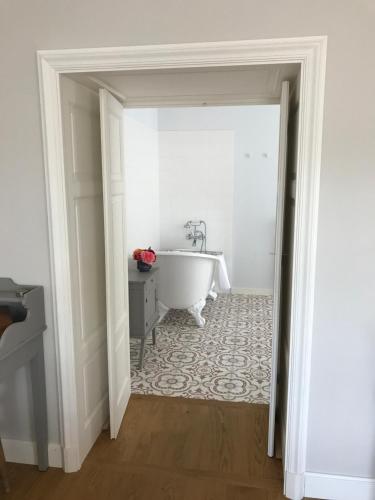 a bathroom with a bath tub in a room at Chambres d'hôtes Vers la Croix in Leynes
