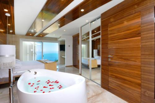 a bathroom with a bath tub and a bedroom at Villa View 4 You in Podstrana