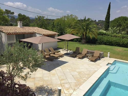 ムージャンにあるStylish villa in Mougins with private poolのプールサイドのパティオ(椅子、パラソル付)