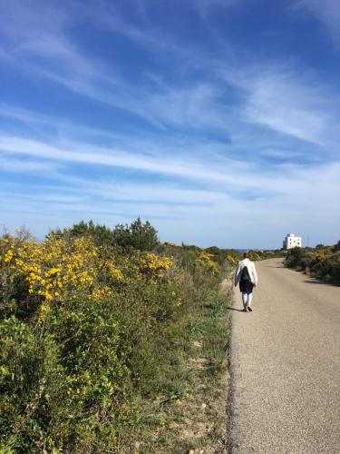 a man walking down a road with a backpack at Camera vista mare, ingresso indipendente in" Villa VìVì" in Siniscola