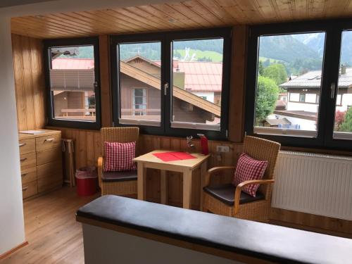 a kitchen with a table and chairs and windows at Hotel Engel in Oberstdorf