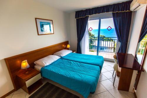 sypialnia z łóżkiem i dużym oknem w obiekcie Splendid Resort w Puli