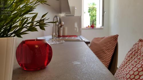 a red vase sitting on a table with a plant at Case Vacanza Marzano in Monopoli