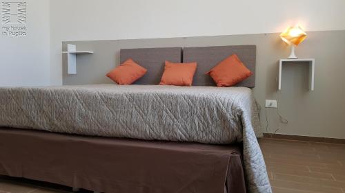 a bedroom with a large bed with orange pillows at Case Vacanza Marzano in Monopoli
