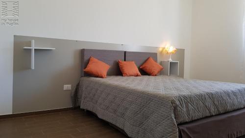 a bedroom with a large bed with orange pillows at Case Vacanza Marzano in Monopoli