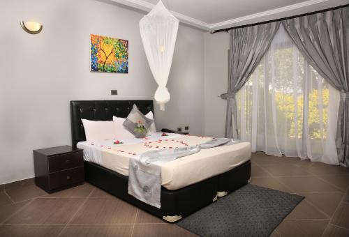 Un dormitorio con una cama grande y una ventana. en Haile Resort Ziway Batu, en Ziway