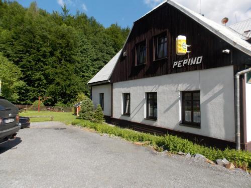 a black and white building with a car parked in front at Chata Pepino in Ludvíkov