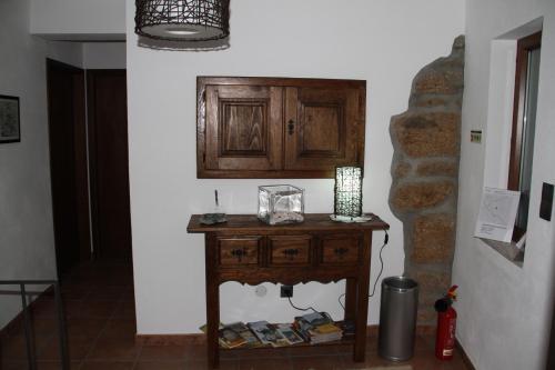 um quarto com uma mesa de madeira e um armário na parede em Alojamento Rural Casa da Eira em Murça