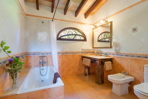 a bathroom with a tub and a toilet and a sink at Agroturisme Ca'n Gaia in Portocolom