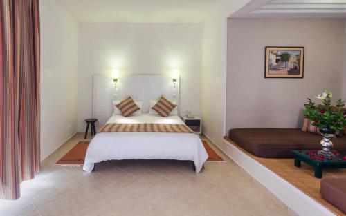 a bedroom with a large bed and a couch at Seabel Alhambra Beach Golf & Spa in Port El Kantaoui