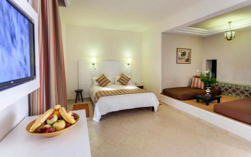 a hotel room with a bed and a bowl of fruit at Seabel Alhambra Beach Golf & Spa in Port El Kantaoui