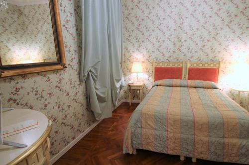 a bedroom with a bed and a dresser and two lamps at Albergo Tre Pozzi in Fontanellato