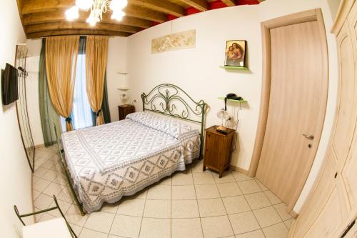 a bedroom with a bed and a room with a door at Dogana Vecchia - Hotel & Residence B&B Ristorante & Pizzeria in Trivignano Udinese