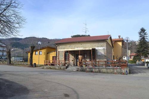 a small yellow building with a red roof on a street at B&B La Casa d'Artista in Ortignano Raggiolo