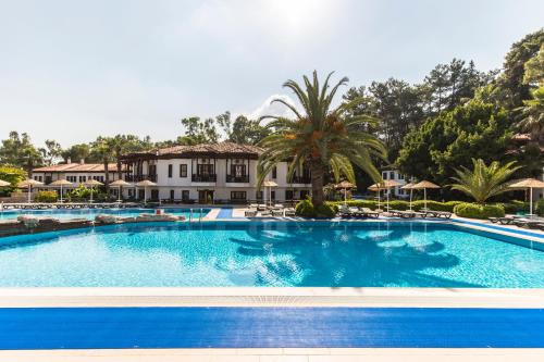 a large swimming pool in front of a house at Yucelen Hotel in Akyaka