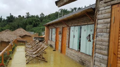 a group of chairs sitting on a porch of a house at Sapa Clay House - Mountain Retreat in Sa Pa