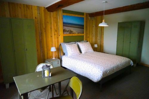 een slaapkamer met een bed, een tafel en groene kasten bij Domaine Airborne in Angoville-au-Plain