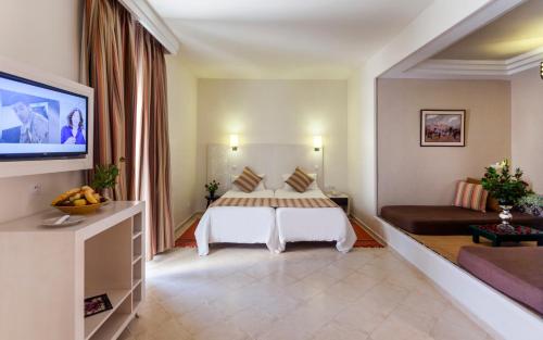a hotel room with a bed and a couch at Seabel Alhambra Beach Golf & Spa in Port El Kantaoui
