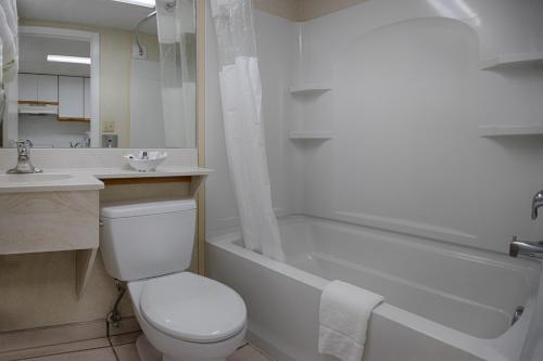 a bathroom with a toilet and a tub and a sink at The Spinnaker in Ocean City