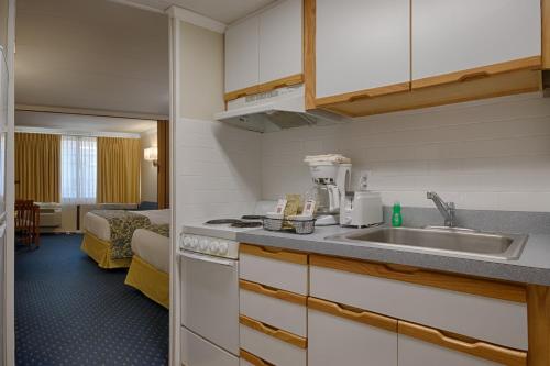 a kitchen with a sink and a room with a bed at The Spinnaker in Ocean City