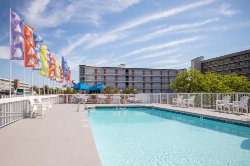 a pool with chairs and flags in front of a hotel at The Spinnaker in Ocean City
