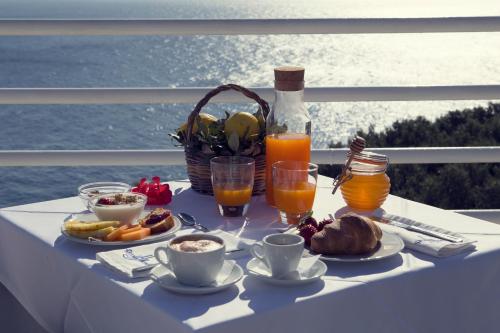 a table with breakfast foods and drinks on a balcony at Hotel Piccolo Mondo in Castro di Lecce