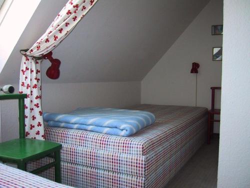 ヴェスターラントにあるKleine-niedliche-Friesenwohnungのベッドルーム1室(カーテン付きのベッド1台付)