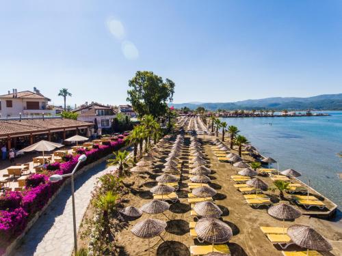 a row of umbrellas on a beach next to the water at Yucelen Hotel in Akyaka