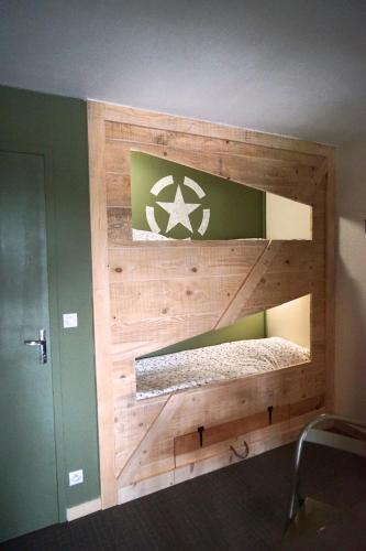 a wooden wall with a bed in a room at Domaine Airborne in Angoville-au-Plain