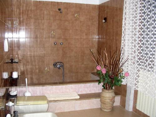 une salle de bain avec une baignoire et un vase avec des fleurs dans l'établissement Agriturismo Da Paola, à Marsiliana d'Albegna