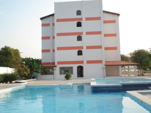 een gebouw met een zwembad voor een gebouw bij Salinas Praia Hotel in Salinas da Margarida