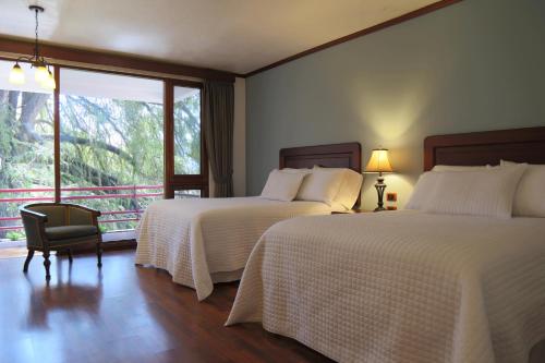 a hotel room with two beds and a window at Hotel Residencia del Sol in Guatemala