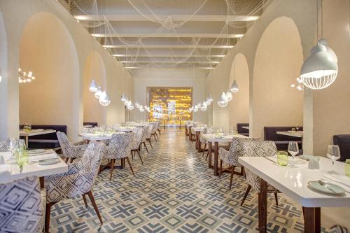 a restaurant with tables and chairs in a room at Grand Lido Negril Au-Naturel, An Autograph Collection All-Inclusive Resort - Adults Only in Negril