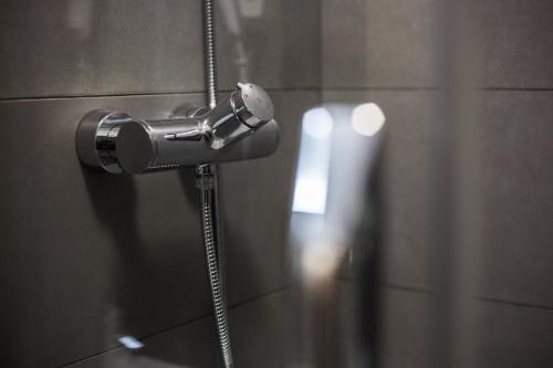 y baño con ducha y cabezal de ducha. en Waw Hotel Airport Okęcie, en Varsovia