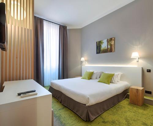 カンヌにあるHôtel La Villa Toscaの大型ベッドとテレビが備わるホテルルームです。