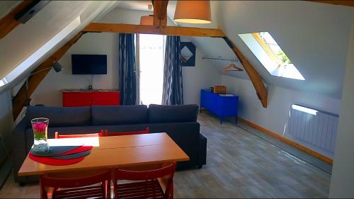 Saint-Jean-Saint-GermainにあるL'Appart Cosy - Proche ZOOPARC de Beauvalのリビングルーム(青いソファ、テーブル付)