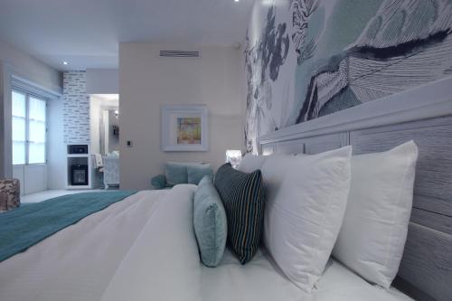 a bedroom with a large white bed with pillows at 1850 Hotel Boutique in Guanajuato