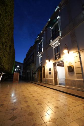 an empty street at night with buildings and lights at 1850 Hotel Boutique in Guanajuato