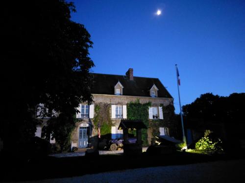 a large house with a moon in the sky at Domaine Airborne in Angoville-au-Plain