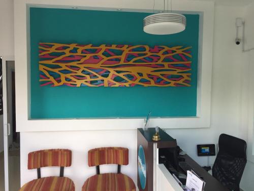 two chairs in an office with a painting on the wall at Aparthotel Siete 32 in Mérida