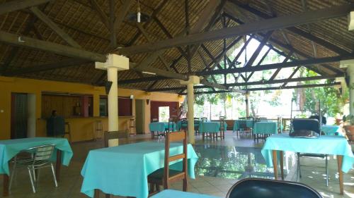 uma sala de jantar com mesas e cadeiras azuis em AR Sun Hotel em Antsiranana